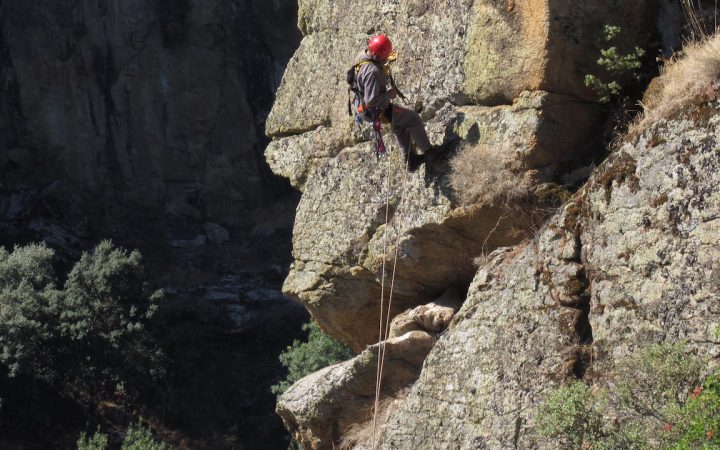 homem a descer arriba com equipamento de escalada