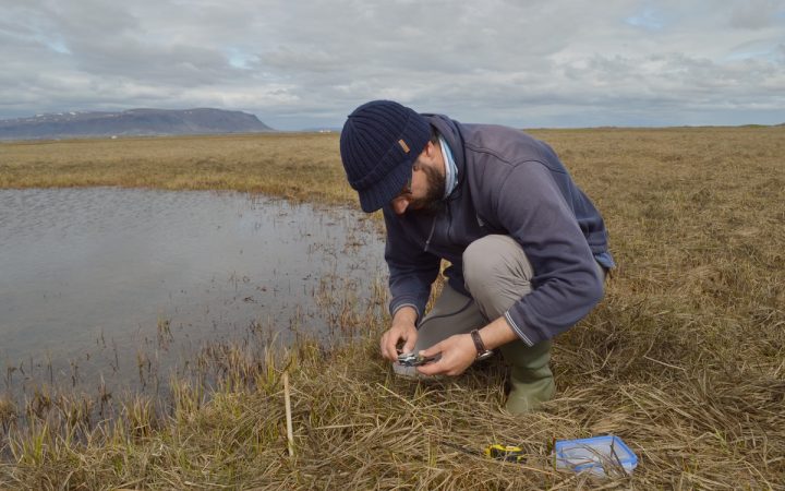 investigador debruçado junto a um lago